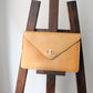 Céline pochette enveloppe en cuir camel et logo triomphe doré