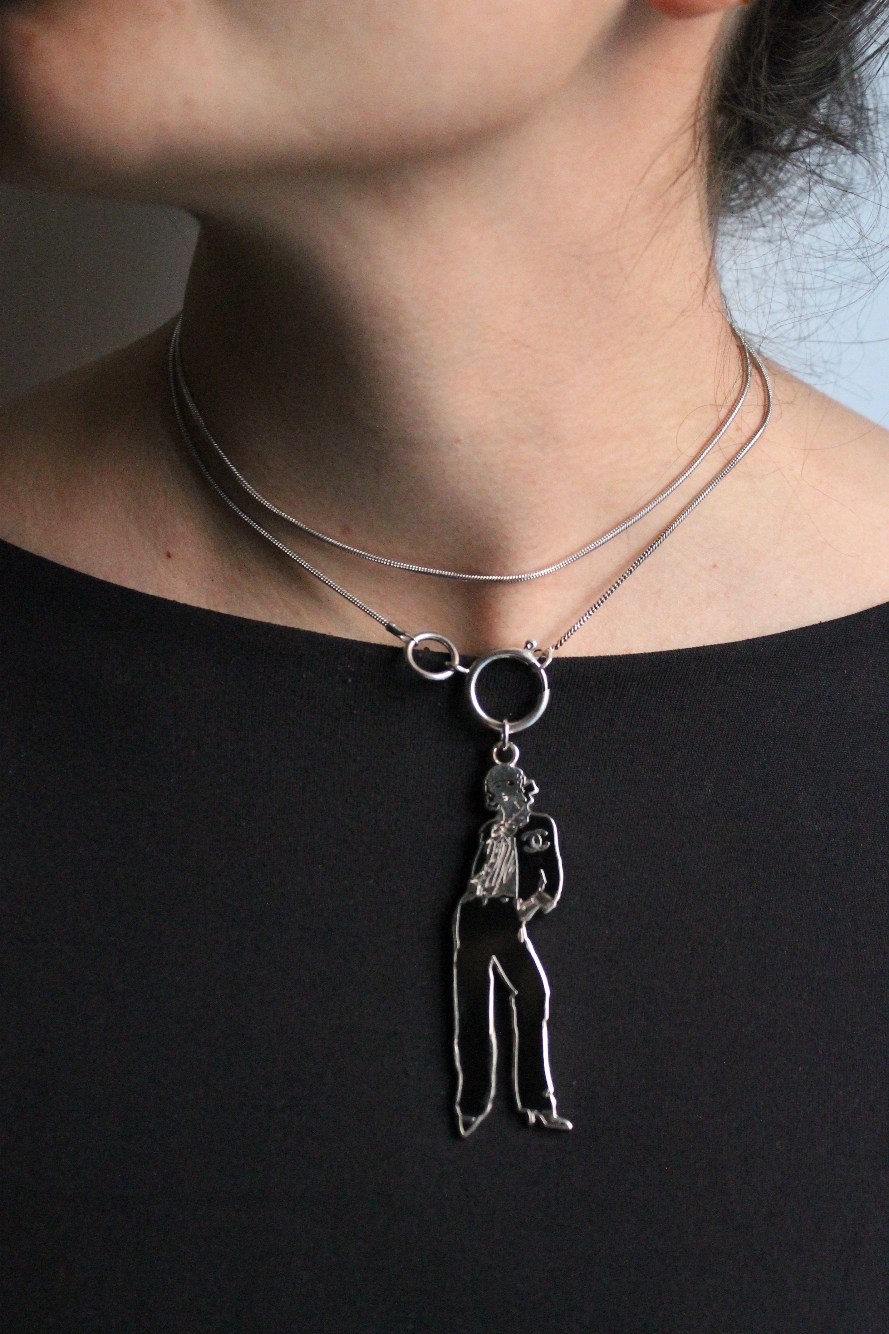 Chanel collier en métal argenté avec pendentif représentant coco chanel