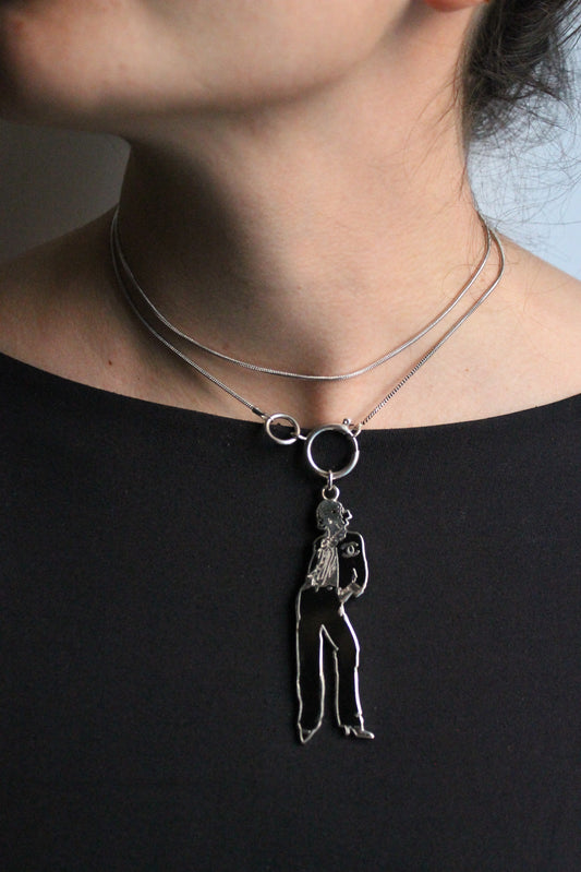 Chanel collier en métal argenté avec pendentif représentant coco chanel